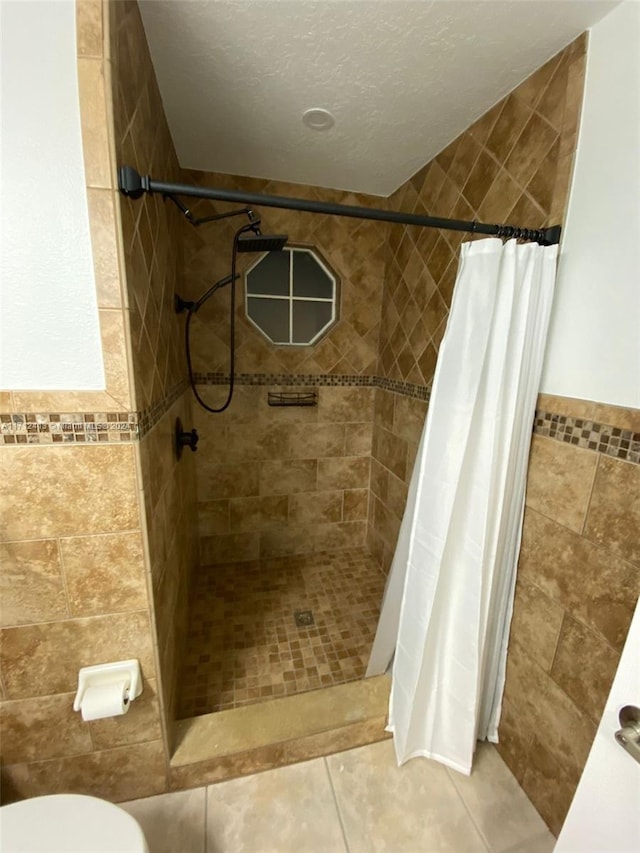 bathroom featuring toilet, tile patterned flooring, a textured ceiling, and a shower with shower curtain