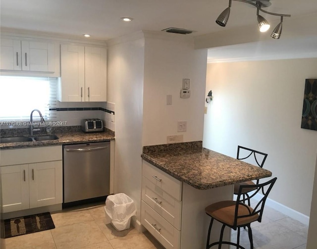 311 S Hollybrook Dr Unit 202, Pembroke Pines, FL 33025 - kitchen featuring sink, stainless steel dishwasher, dark stone counters, a breakfast bar, and white cabinets