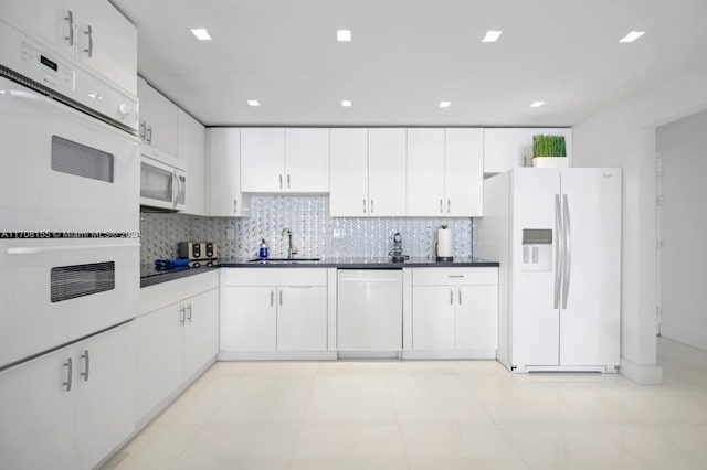 kitchen with white appliances, white cabinets, sink, light tile patterned floors, and tasteful backsplash