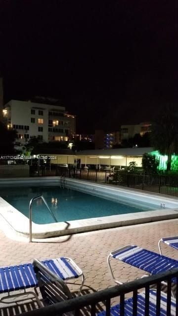 pool at twilight featuring a patio