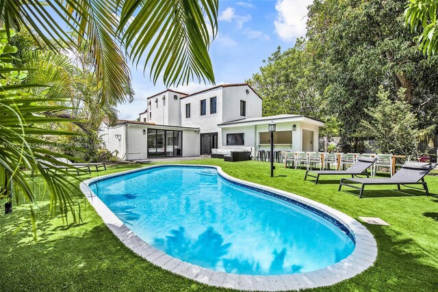 view of swimming pool with a lawn