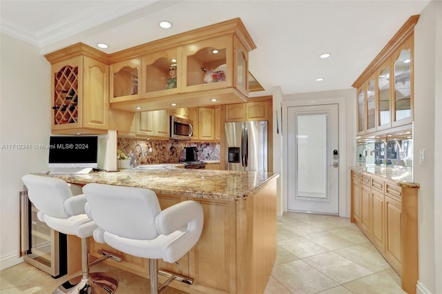 kitchen featuring kitchen peninsula, light brown cabinetry, light tile patterned flooring, and stainless steel appliances