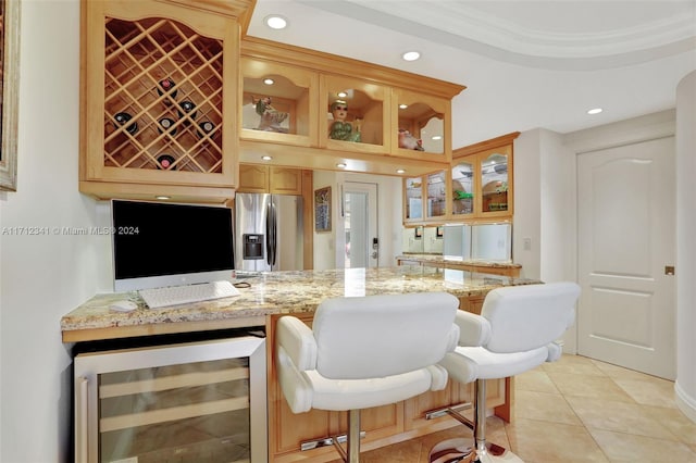 interior space featuring light stone countertops, stainless steel fridge, ornamental molding, beverage cooler, and light tile patterned floors