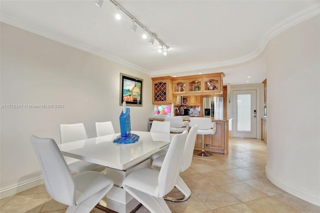 tiled dining room featuring ornamental molding and rail lighting