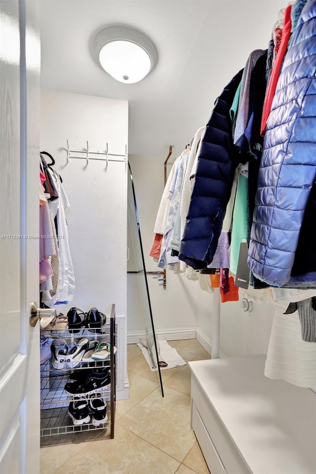 walk in closet with light tile patterned floors