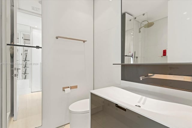 bathroom featuring tiled shower, tile patterned flooring, and toilet