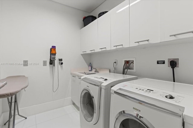 washroom featuring cabinets, sink, separate washer and dryer, and light tile patterned flooring