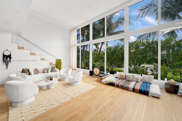 living room featuring hardwood / wood-style floors, a towering ceiling, and expansive windows