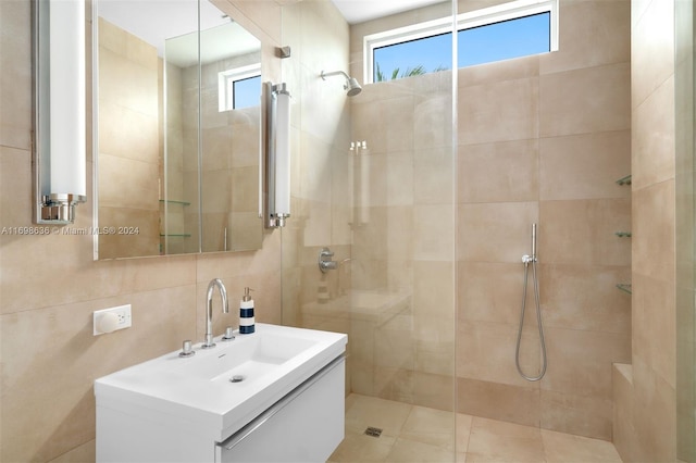 bathroom featuring tiled shower, tile walls, vanity, and tasteful backsplash