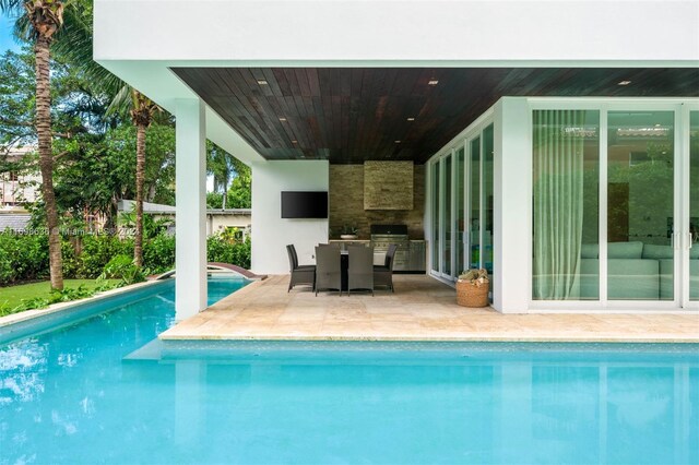 view of swimming pool with a patio area and exterior kitchen