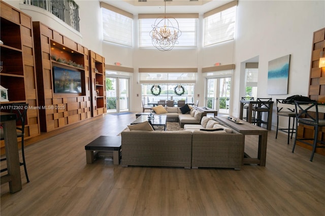 living room featuring dark hardwood / wood-style flooring, french doors, and an inviting chandelier