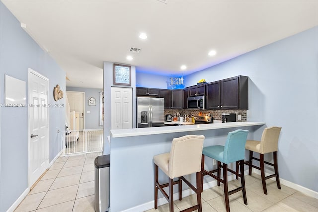 3217 SE 4th Ct Unit 3217, Homestead, FL 33033 - kitchen featuring a kitchen bar, tasteful backsplash, a peninsula, light countertops, and stainless steel appliances