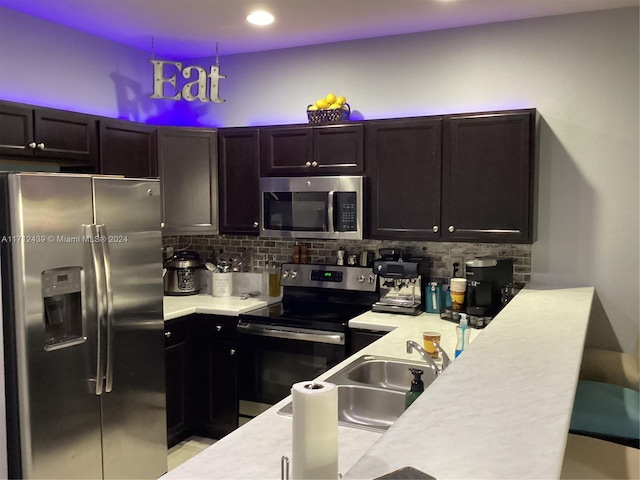 kitchen with decorative backsplash, appliances with stainless steel finishes, decorative light fixtures, and sink