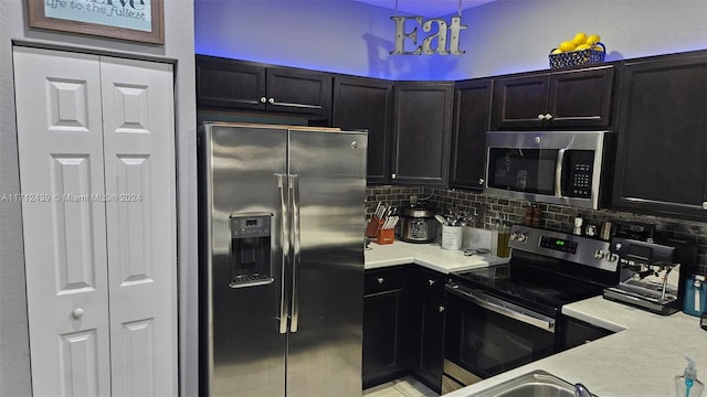 kitchen with backsplash, hanging light fixtures, and appliances with stainless steel finishes