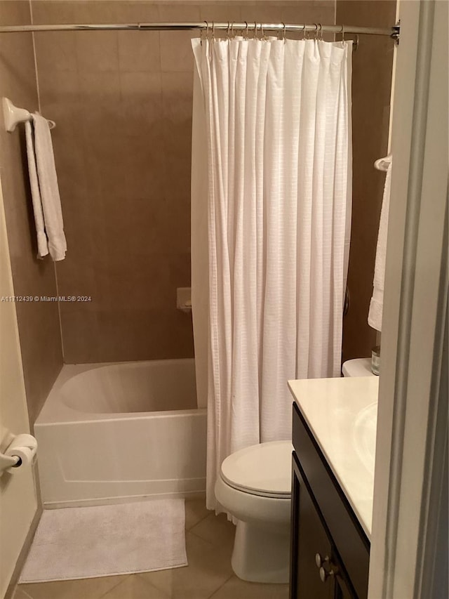 full bathroom featuring tile patterned floors, shower / bath combo with shower curtain, vanity, and toilet