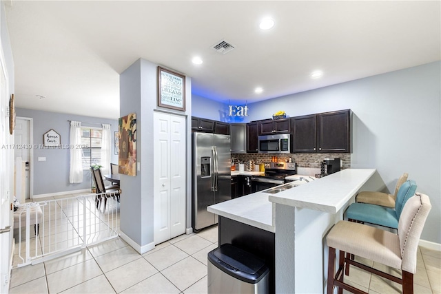 3217 SE 4th Ct Unit 3217, Homestead, FL 33033 - kitchen featuring light countertops, appliances with stainless steel finishes, a breakfast bar, a peninsula, and light tile patterned flooring