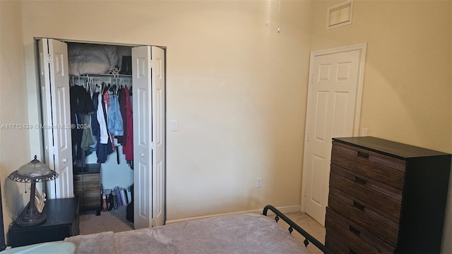 bedroom with light carpet and a closet