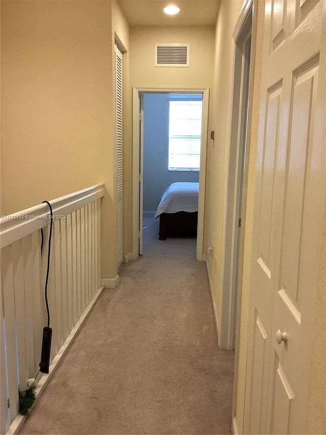 corridor featuring light colored carpet