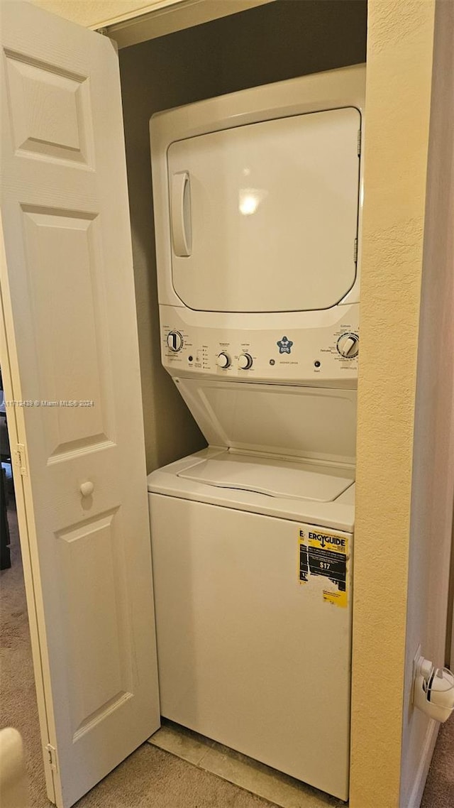 washroom featuring carpet flooring and stacked washer / drying machine