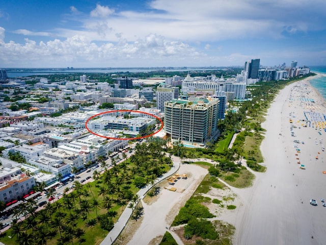 drone / aerial view featuring a water view and a beach view