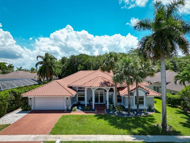 mediterranean / spanish home featuring a front yard and a garage