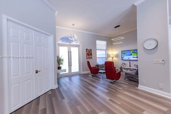 entrance foyer featuring hardwood / wood-style floors, ornamental molding, and french doors