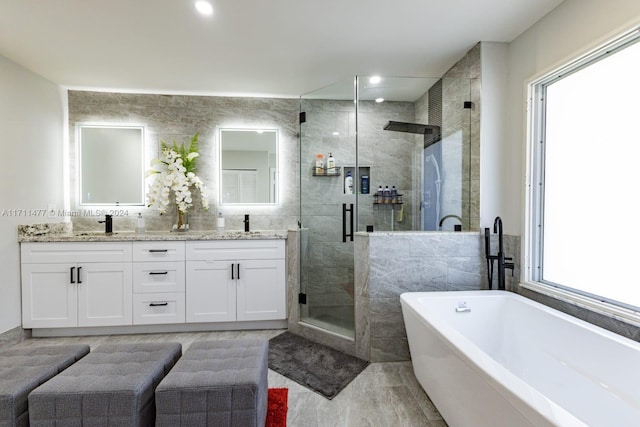 bathroom with vanity and shower with separate bathtub