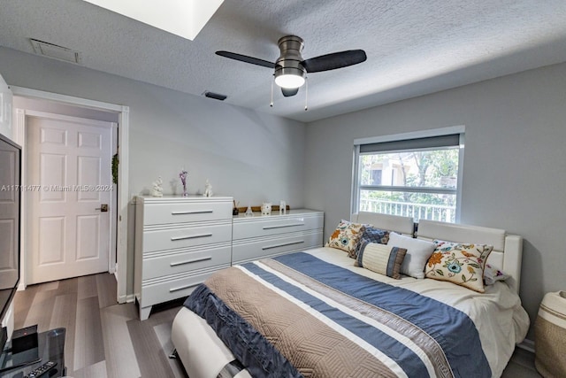 bedroom featuring a textured ceiling, dark hardwood / wood-style flooring, and ceiling fan