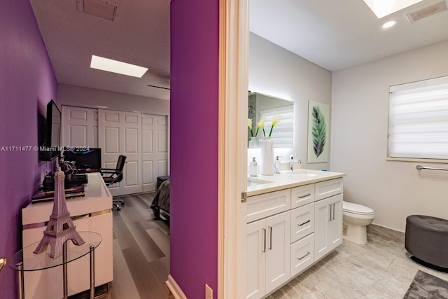 bathroom with vanity, hardwood / wood-style flooring, and toilet