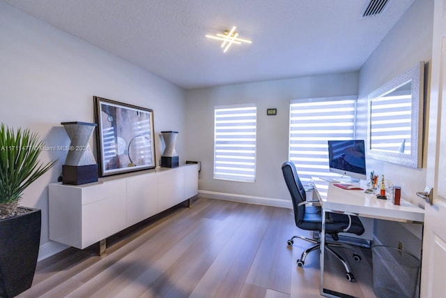 office space with light hardwood / wood-style floors and a textured ceiling