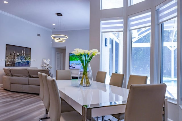 dining area featuring a chandelier, hardwood / wood-style flooring, and ornamental molding