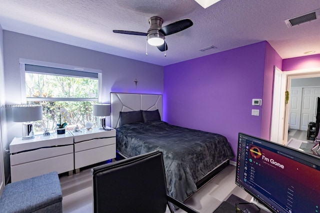 bedroom with ceiling fan and a textured ceiling