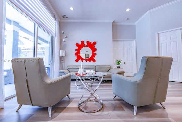 living room with crown molding and light hardwood / wood-style floors