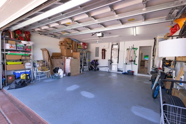 garage with electric panel and a garage door opener