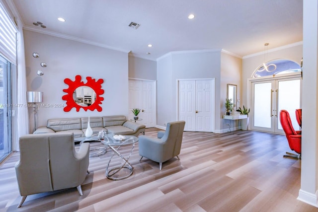 living room with crown molding, french doors, and light hardwood / wood-style floors