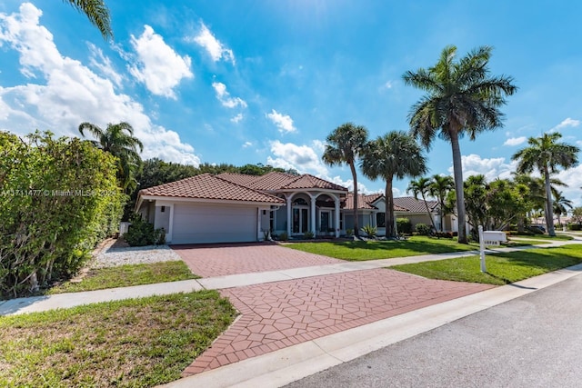 mediterranean / spanish house with a front yard and a garage