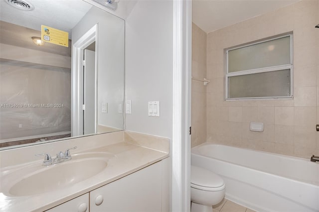 full bathroom with tiled shower / bath combo, tile patterned flooring, a textured ceiling, toilet, and vanity