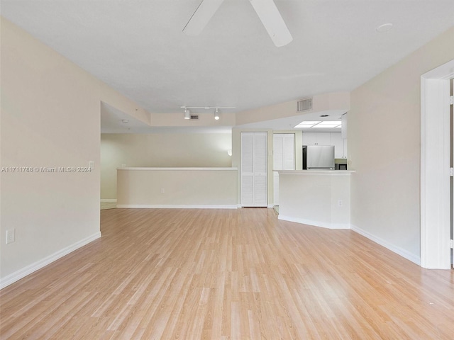 unfurnished living room featuring light hardwood / wood-style floors and rail lighting