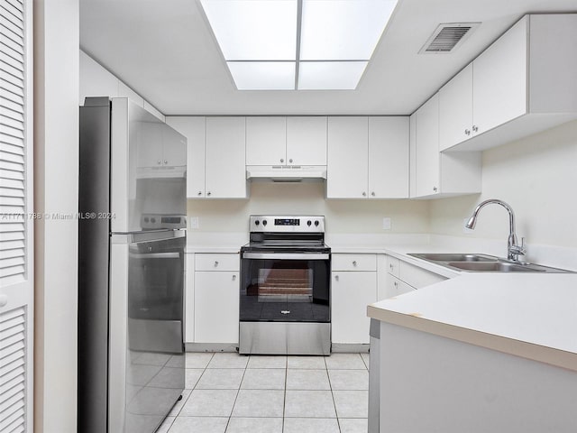 kitchen with light tile patterned flooring, appliances with stainless steel finishes, white cabinetry, and sink