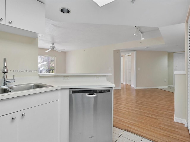 kitchen with dishwasher, light tile patterned floors, white cabinetry, and sink