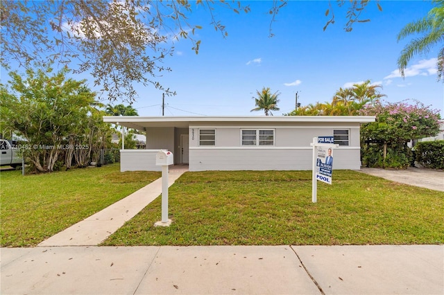 view of front of property with a carport and a front yard