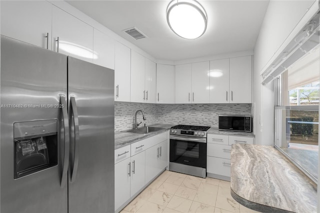kitchen featuring sink, white cabinetry, stainless steel appliances, and tasteful backsplash