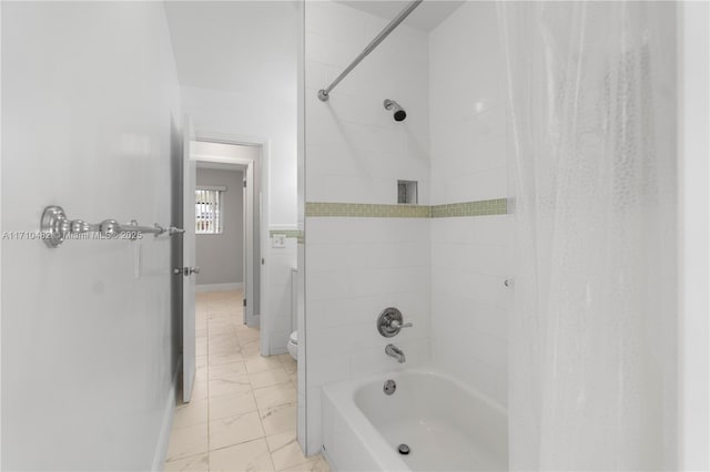 bathroom featuring toilet and tiled shower / bath