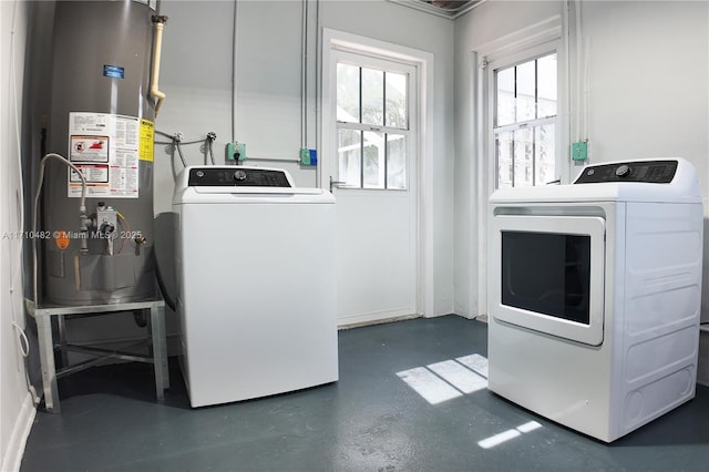 clothes washing area with gas water heater and independent washer and dryer
