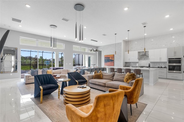 living room featuring sink, light tile patterned floors, and a textured ceiling