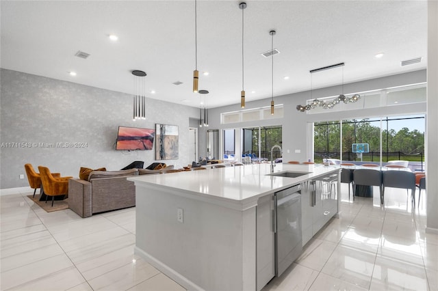 kitchen with sink, dishwasher, a chandelier, hanging light fixtures, and a large island