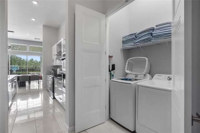 clothes washing area with independent washer and dryer and a textured ceiling