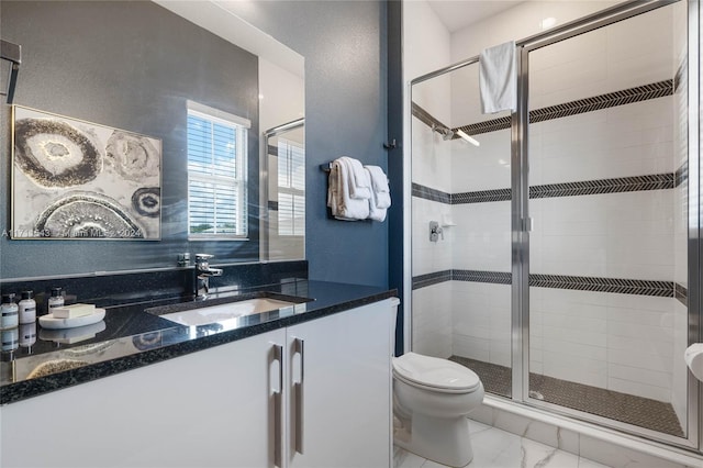 bathroom featuring vanity, toilet, and a shower with shower door