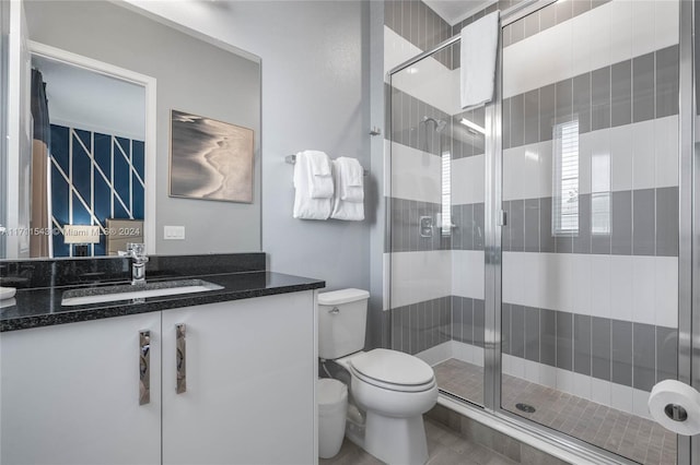 bathroom featuring tile patterned floors, vanity, toilet, and walk in shower