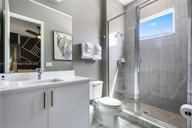 bathroom featuring vanity, tile patterned floors, ceiling fan, toilet, and walk in shower